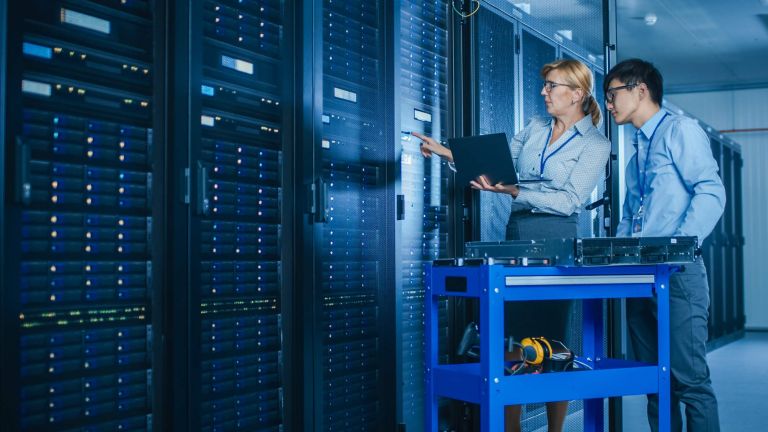 In the Modern Data Center: Engineer and IT Specialist Work with Server Racks, on a Pushcart Equipment for Installing New Hardware. Specialists Doing Maintenance and Diagnostics of the Database.