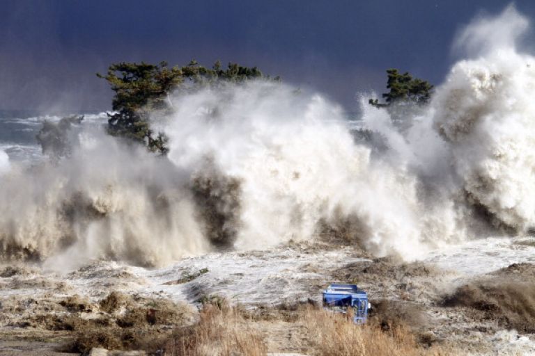 This picture taken on March 11, 2011 by Sadatsugu Tomizawa and released via Jiji Press on March 21, 2011 shows tsunami waves hitting the coast of Minamisoma in Fukushima prefecture. The number of people confirmed dead or listed as missing in Japan neared 22,000, 10 days after a massive earthquake and tsunami struck the country's northeast coast. AFP PHOTO / JIJI PRESS (Photo credit should read SADATSUGU TOMIZAWA/AFP via Getty Images).